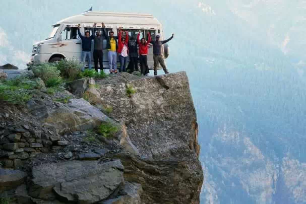 Grupa ludzi i bus osobowy na skale
